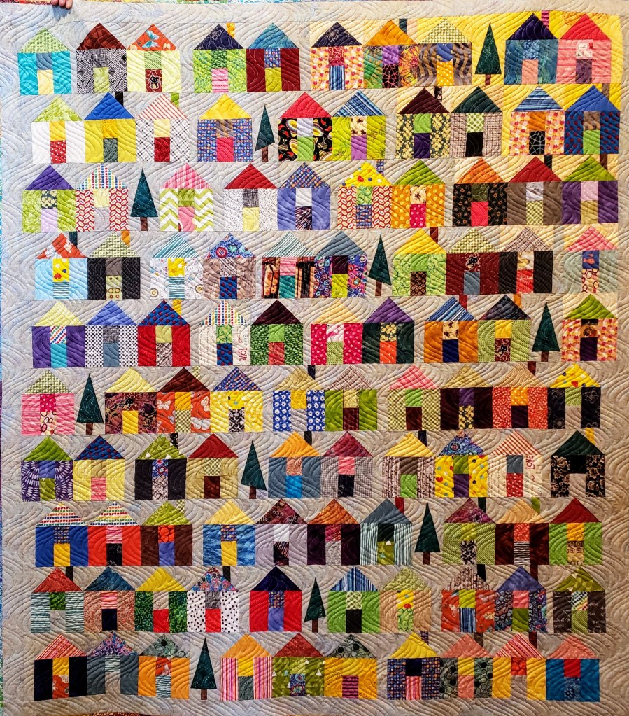 Janet: Quarantined Village 2020,  from the Moda Village pattern with a design change to add trees. Made from scraps and stash. (Machine quilted by Janet Haines.)